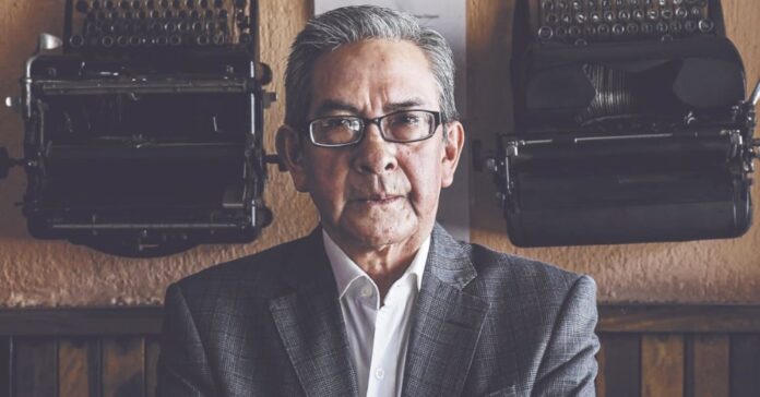 Retrato del periodista cultural José Luis Martínez S. entre dos máquinas de escribir